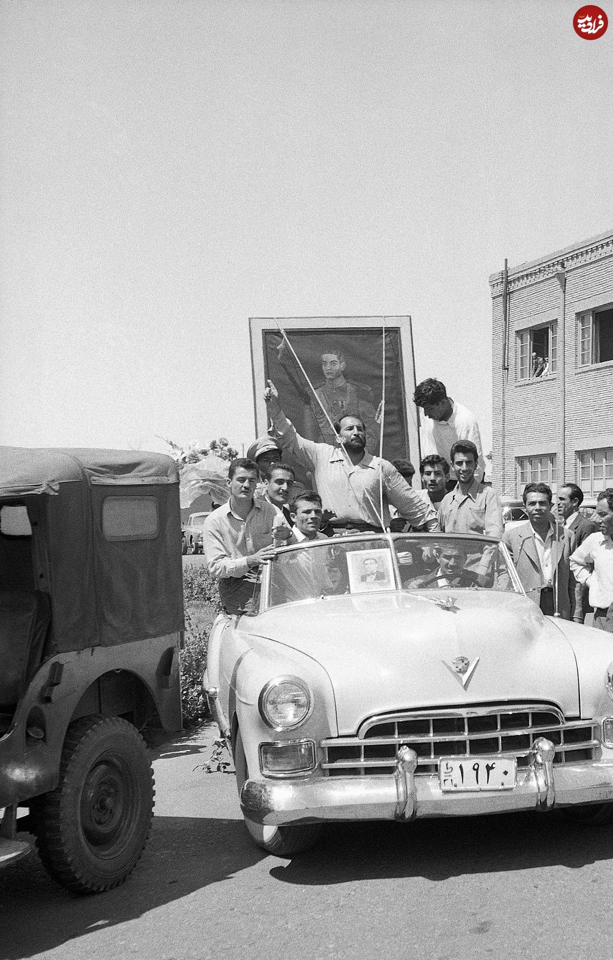 عکس؛ سفر در زمان؛ شعبان بی مخ در حال چرخاندن عکس شاه در تهران؛ 28 مرداد 1332